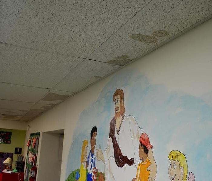A flooded Sunday school room with water damage to the ceiling.