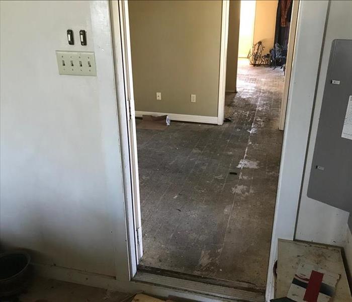 Flood damage throughout a room and hallway.