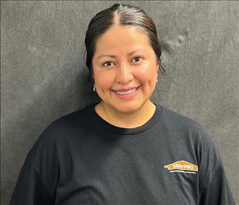 Happy smiling girl wearing a black shirt with her black hair pulled back behind her head. 