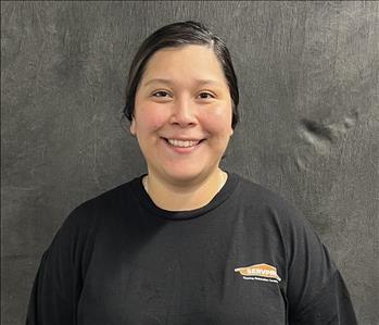 Happy smiling girl wearing a black shirt with her black hair pulled back behind her head. 