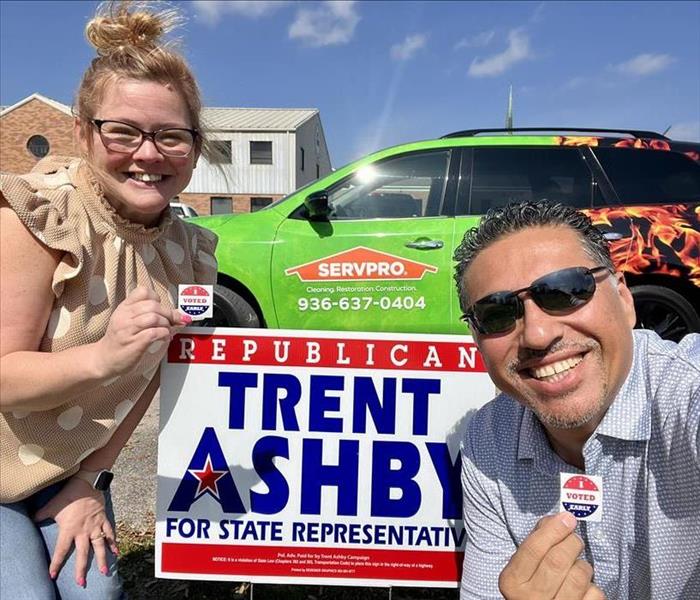 two people holding i voted stickers