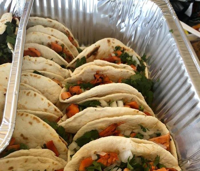 A disposable foil pan filled with tacos.