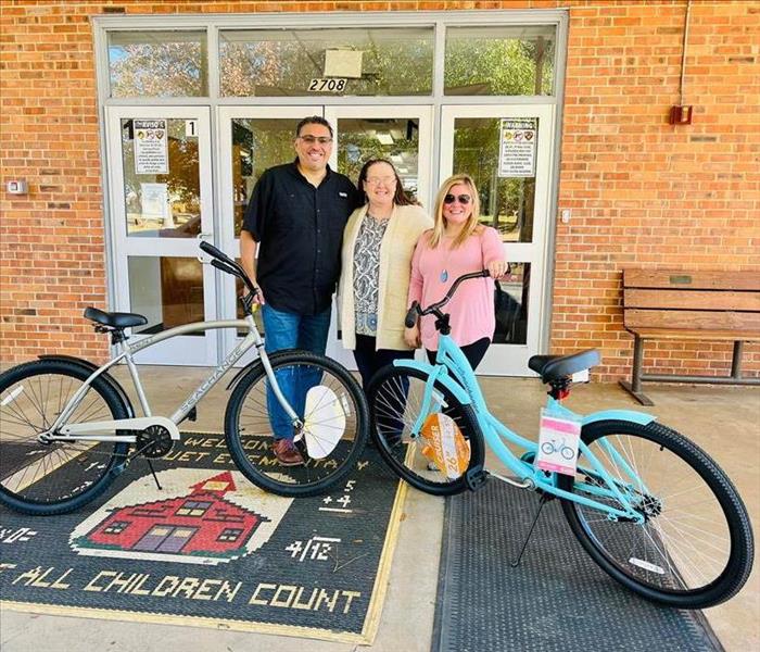 three people posing for picture with bicycles
