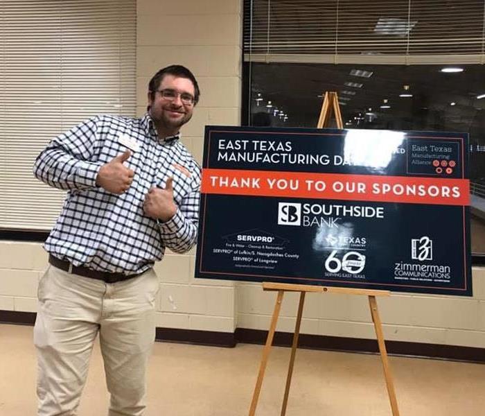 A man standing in front of a sign