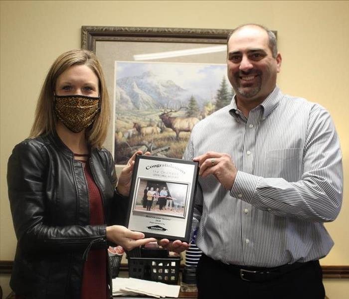 Woman and man holding plaque