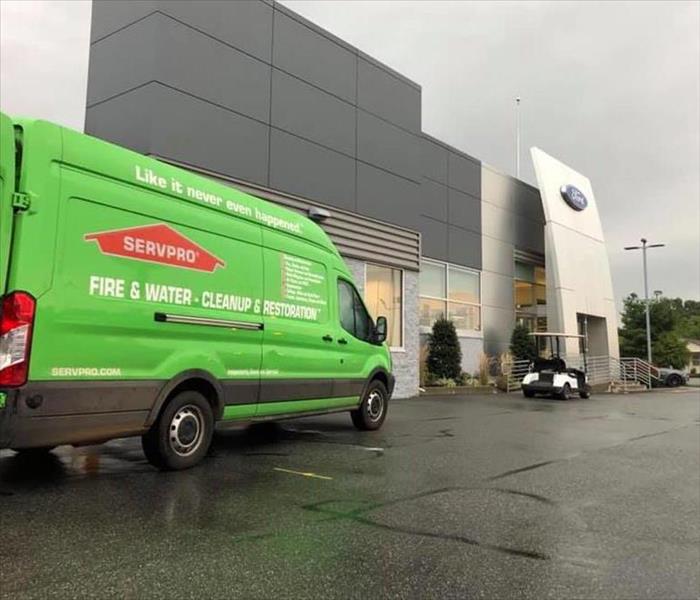 A SERVPRO truck parked in front of a car dealership.