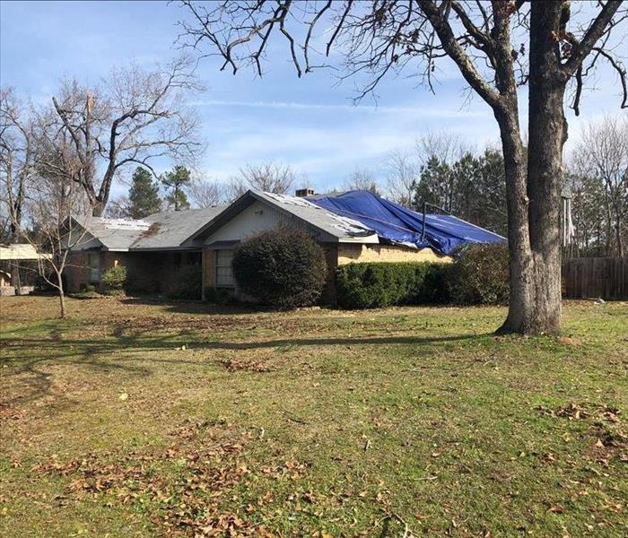 A home with a tarp on the roof.