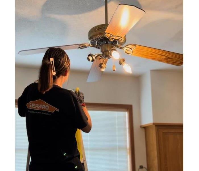 SERVPRO technician cleaning ceiling fan