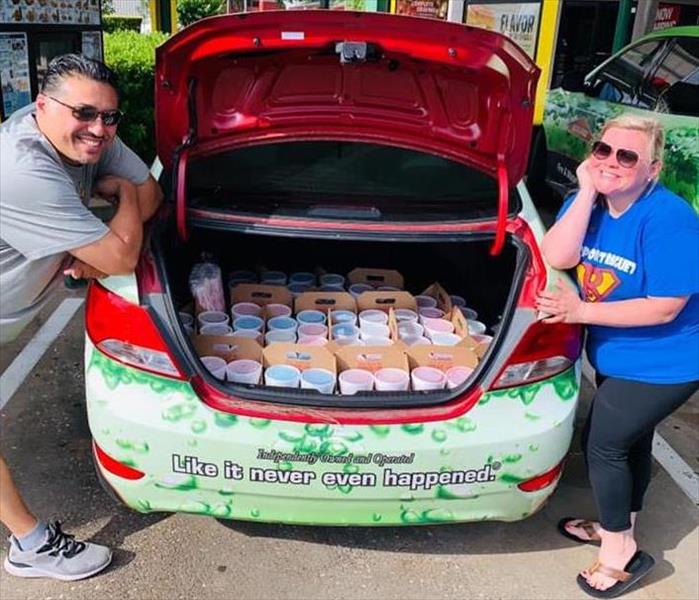 Patrick and Candice posing with a trunk full of frozen drinks