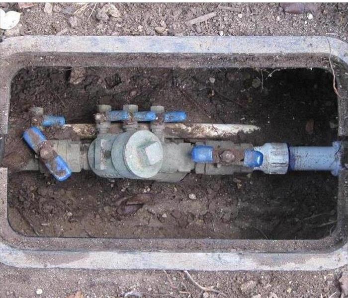 A Main water valve box open in the ground 