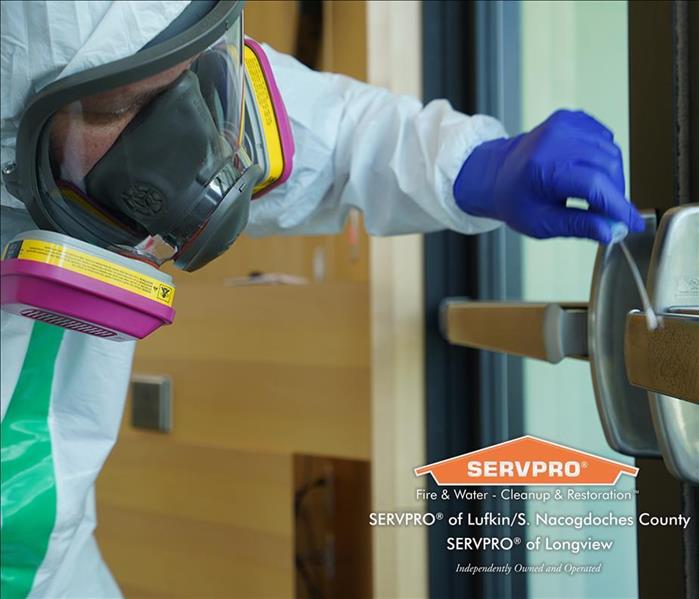 SERVPRO technician cleaning door