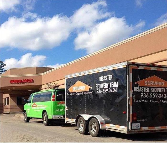 A SERVPRO truck out in front of a large building.