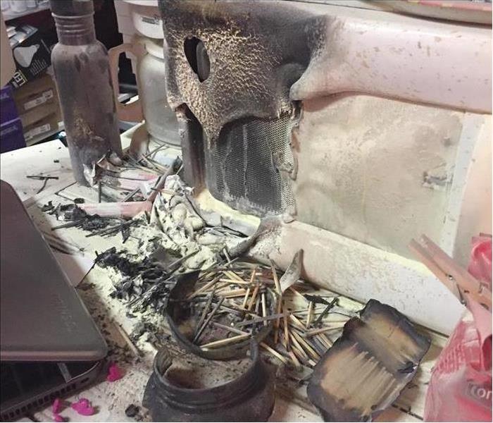 A burned department store rack of clothes after a fire.