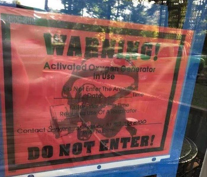 A hazardous materials warning sign on the window of a home.