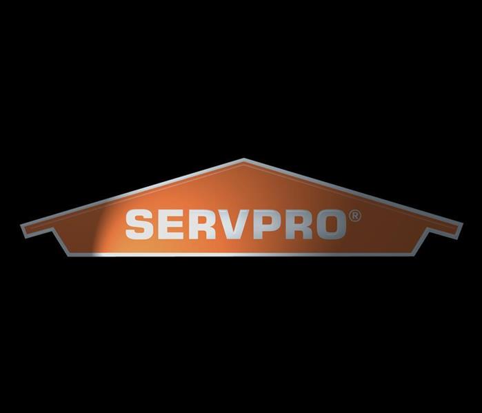 SERVPRO logo on a dark background with a light shining on it