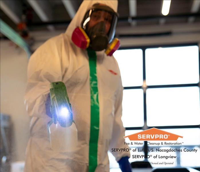 SERVPRO employee in biohazard suit cleans